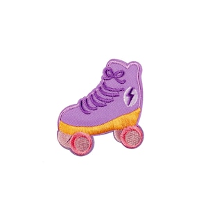 Könnte beinhalten: Lilafarbener Rollschuh mit gelben Rollen und rosa Akzenten. Der Rollschuh hat ein Blitz-Design an der Seite.