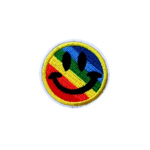 Könnte beinhalten: Gestickter Smiley-Patch mit Regenbogen. Der Patch ist gelb, rot, orange, grün, blau und lila.