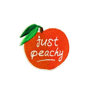 May include: An orange peach with a green leaf stem and the text "just peachy" in white cursive writing.
