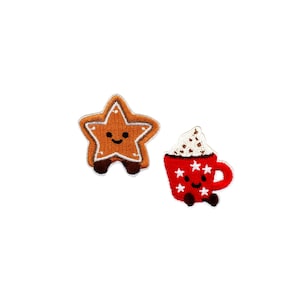 May include: Two embroidered patches: a smiling gingerbread star and a red mug of hot cocoa with whipped cream. The star is brown with white trim and brown feet. The mug has white star accents and a smiling face.