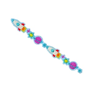 Puede incluir: Un cohete azul y blanco con llamas naranjas, un planeta rosa y estrellas amarillas sobre un fondo azul claro.