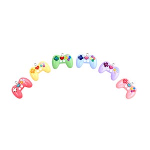 May include: A set of six colorful plastic game controller charms. The charms are in a rainbow color scheme, with each controller featuring a different color. The charms are perfect for adding a touch of fun to your keys, bags, or other accessories.
