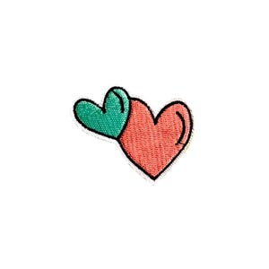 Pode incluir: Um coração vermelho com um coração verde no topo. Os corações são delineados em preto.