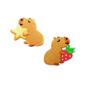 May include: Two embroidered iron-on patches featuring a cartoon capybara. One capybara is holding a yellow star and the other is holding a red strawberry.