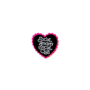 May include: Black heart-shaped pin with a pink border. The pin says "Social Anxiety Social Club" in white text.