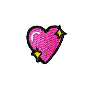 May include: Pink heart-shaped patch with black outline and yellow stars.