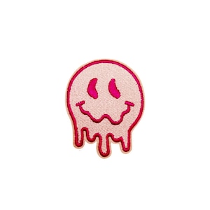 May include: Pink melting smiley face iron-on patch with a pink outline.