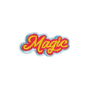 May include: Embroidered patch with the word "Magic" in a cursive font. The word is in yellow with a red outline, set against a light blue cloud-shaped background. The patch is designed to be sewn or ironed onto fabric.