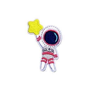 Op de afbeelding: Een geborduurde strijkpatch van een cartoon-astronaut in een wit ruimtepak met een rode riem en roze laarzen, die naar een gele ster reikt.