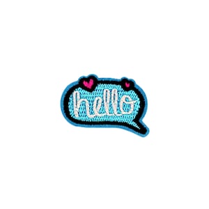 May include: A blue speech bubble with a black outline and white embroidered text that says "hello". There are two pink hearts above the text.