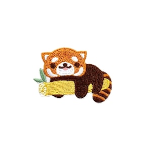 May include: Embroidered patch of a red panda sleeping on a yellow bamboo branch. The red panda has a brown body with white facial markings and a curled tail.
