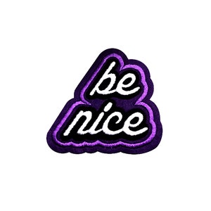 May include: Purple and white embroidered patch with the text "be nice" in a cursive font.