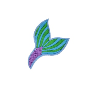May include: A blue and green mermaid tail with purple scales. The tail is embroidered and has a light blue outline.