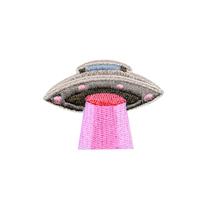 Może przedstawiać: Szary i srebrny UFO z różowym promieniem światła wychodzącym z dołu. UFO ma niebieskie okno i kilka małych różowych świateł.