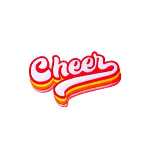 May include: A retro-style iron-on patch with the word "Cheer" in a white font with red and orange outlines.