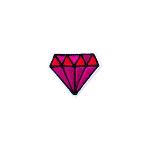 May include: A diamond-shaped patch with a vibrant design. The patch features a deep pink centre with red accents at the top, outlined in black. The patch is bordered with white stitching, creating a clean, finished look. This patch is suitable for clothing or accessories.