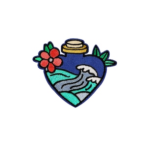 Puede incluir: Una botella azul en forma de corazón con un diseño de ola y una flor roja en el lateral. La botella tiene una tapa dorada y está bordada.