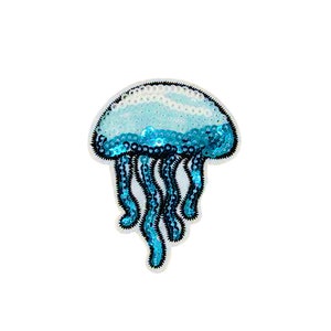 Può includere: Un cerotto di medusa con paillettes blu e bianche. La medusa ha un corpo a forma di campana e lunghi tentacoli fluttuanti.