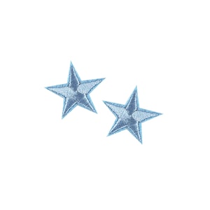 Puede incluir: Dos estrellas bordadas de color azul claro sobre un fondo blanco.