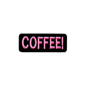 May include: A black rectangular patch with the word "COFFEE!" embroidered in pink, featuring a bold, stylized font. The patch is designed for application on clothing or accessories.