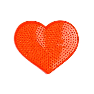 May include: Orange heart-shaped bead board for crafting. The board is made of plastic and has a grid of small holes for holding beads.
