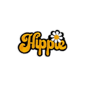 May include: A yellow embroidered patch with the word "Hippie" in a retro font, with a white daisy with a yellow center above the word.