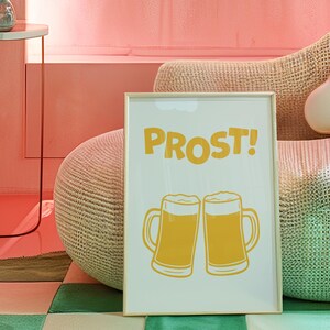 May include: A framed print with the word "PROST!" in yellow letters and two yellow cartoon beer mugs clinking together.