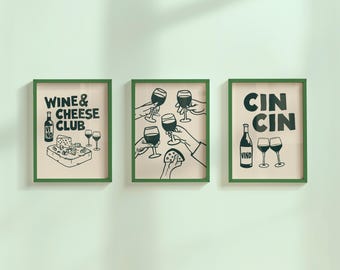May include: Three framed art prints with green frames. The prints feature black and white illustrations of wine glasses, cheese, and wine bottles. Text includes "Wine & Cheese Club" and "Cin Cin".