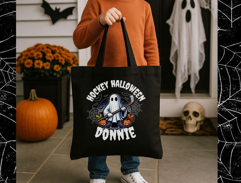 K&ouml;nnte beinhalten: Eine schwarze Tragetasche mit einer Grafik eines Geistes, der Schlittschuhe tr&auml;gt und einen Hockeyschl&auml;ger h&auml;lt. Das Design zeigt orangefarbene K&uuml;rbisse, Spinnweben und Flederm&auml;use sowie den wei&szlig;en Schriftzug HOCKEY HALLOWEEN DONNIE in Bogenform.
