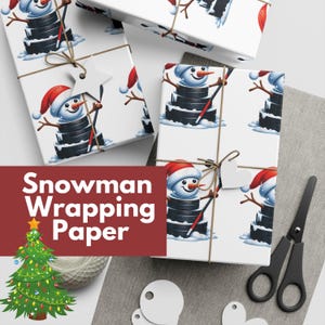 May include: White wrapping paper featuring a snowman design made of hockey pucks, wearing Santa hats. The wrapped gifts are tied with twine and have star-shaped tags. The image also shows scissors and gift tags.