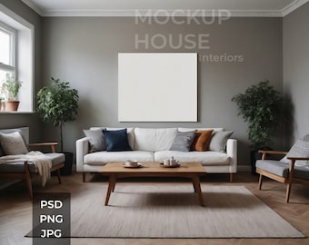 May include: A white couch with pillows in a living room setting. The couch is in front of a large white framed picture on a gray wall. There are two plants, a coffee table, and two chairs in the room. The text "MOCKUP HOUSE interiors" is on the wall.