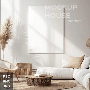 Puede incluir: Un sofá blanco con almohadas beige en una sala de estar con un marco blanco grande, una silla de mimbre, una mesa auxiliar de mimbre y una mesa de café de mimbre. La habitación tiene una pared blanca con el texto "MOCKUP HOUSE Interiors" y una ventana grande con luz natural.