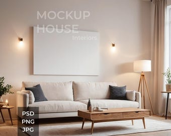 May include: A white sofa with two pillows sits in a living room with a large white frame on the wall. The frame has the text "MOCKUP HOUSE Interiors" on it. There is a wooden coffee table in front of the sofa and a floor lamp in the corner.