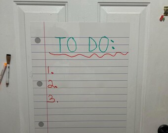 May include: A white, lined, rectangular whiteboard with the words "TO DO:" written in green marker. Below the text are three numbered lines in red. The whiteboard is attached to a white door.