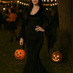 May include: A black velvet dress with long, flared sleeves and a V-neck. The dress is worn with a black wig and red lipstick. The person is holding an orange jack-o'-lantern bucket. A lit pumpkin sits on the ground.