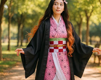 Puede incluir: Un atuendo de cosplay con un kimono rosa con un patrón geométrico, un abrigo negro y un obi a cuadros rojos y blancos. El personaje tiene cabello negro largo con puntas naranjas y un accesorio para el cabello rosa. El fondo es una escena borrosa al aire libre.
