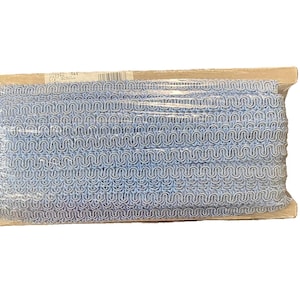 May include: A roll of light blue decorative trim with a wavy, looped design. The trim is packaged in clear plastic and mounted on a wooden spool. The trim is suitable for sewing and craft projects.