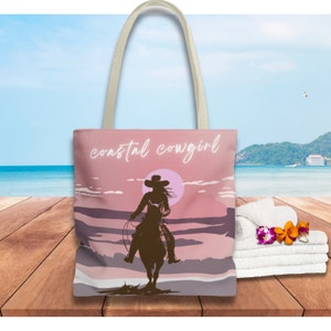May include: A pink tote bag with a silhouette of a cowgirl riding a horse against a sunset backdrop. The text "coastal cowgirl" is printed on the bag.