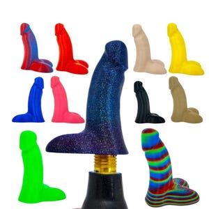May include: A collection of vibrantly colored dildos in various shades, including blue, red, pink, green, yellow, and black. Some have unique patterns, and one is mounted on a black base with a gold-colored screw.