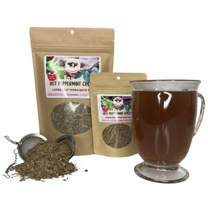 Peut inclure: Image d'une tasse en verre transparente remplie d'une boisson brune, &agrave; c&ocirc;t&eacute; de deux sachets en papier brun et d'un petit sachet, tous &eacute;tiquet&eacute;s "Hot Peppermint Coco Loose Leaf Yerba Mate Tea". Un infuseur &agrave; th&eacute; avec du th&eacute; en vrac est &eacute;galement pr&eacute;sent.