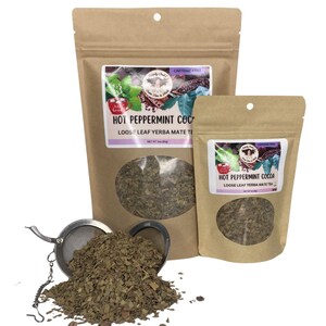 Peut inclure: Deux sachets en papier brun de th&eacute; yerba mat&eacute; en feuilles en vrac, un grand et un petit, avec une fen&ecirc;tre transparente montrant le th&eacute; &agrave; l'int&eacute;rieur. Les sachets portent l'inscription "Hot Peppermint Cocoa". Une boule &agrave; th&eacute; en acier inoxydable est remplie de th&eacute;.