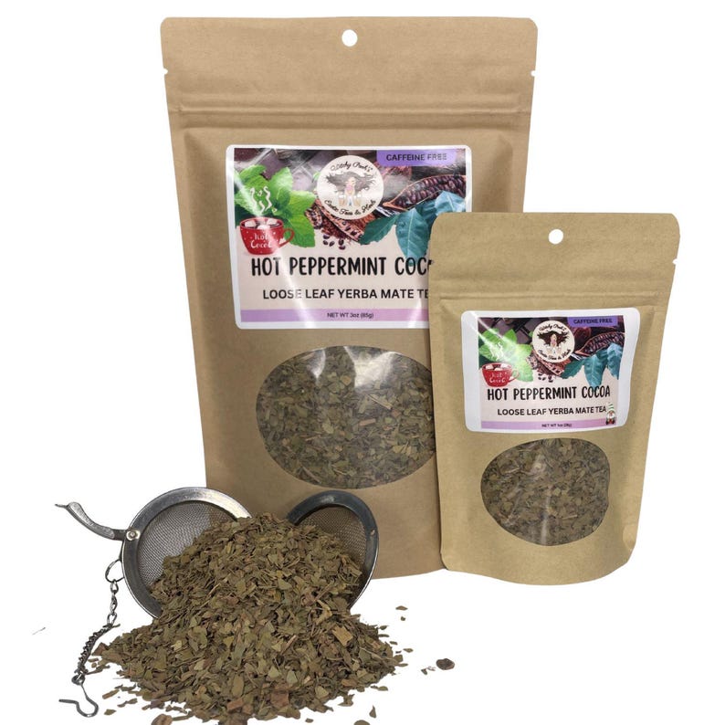 Peut inclure: Deux sachets en papier brun de th&eacute; yerba mat&eacute; en feuilles en vrac, un grand et un petit, avec une fen&ecirc;tre transparente montrant le th&eacute; &agrave; l'int&eacute;rieur. Les sachets portent l'inscription "Hot Peppermint Cocoa". Une boule &agrave; th&eacute; en acier inoxydable est remplie de th&eacute;.