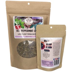 Peut inclure: Deux sachets en papier brun contenant du th&eacute; yerba mat&eacute; en feuilles en vrac. Le plus grand sachet a une fen&ecirc;tre transparente montrant les feuilles de th&eacute; et une &eacute;tiquette indiquant "Hot Peppermint Cocoa". Le plus petit a une &eacute;tiquette avec les ingr&eacute;dients et les instructions.