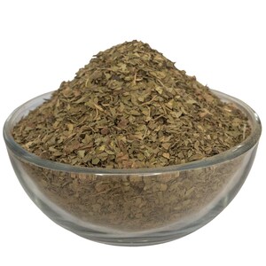 Peut inclure: Un bol en verre transparent rempli d'herbes vertes et s&egrave;ches. Les herbes sont finement hach&eacute;es et semblent &ecirc;tre un ingr&eacute;dient culinaire. Le bol est pos&eacute; sur un fond blanc uni, mettant en valeur la texture et la couleur des herbes.