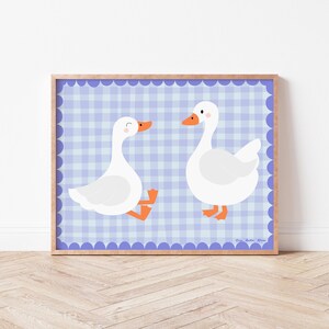 May include: Two white geese with orange beaks and feet are facing each other on a blue and white gingham background. The geese are on a blue background with white scalloped edges.