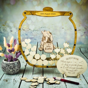 Può includere: Libro degli ospiti in legno a tema Winnie the Pooh con un design a forma di barattolo di miele. Il libro degli ospiti ha un cartello che dice "Per favore, firma un cuore o lascialo nella cornice in modo che mi ricordi sempre i miei cari che sono venuti".