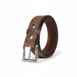 May include: A brown leather belt with a silver-colored buckle. The belt has two silver rivets near the buckle. The leather has a distressed appearance. The belt is approximately 1.5 inches wide.