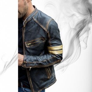 May include: A distressed black leather jacket with gold stripes on the sleeves and gold zippers. The jacket has a classic biker style with a stand-up collar and a fitted silhouette. The leather has a worn, vintage look.