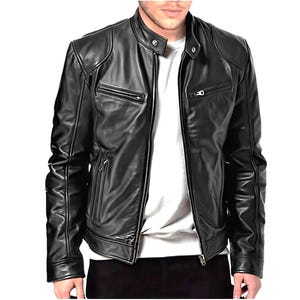 May include: Black leather jacket with a stand-up collar, two zippered chest pockets, and two side pockets. The jacket has a front zipper closure and a quilted design on the shoulders. The model is wearing a white t-shirt underneath.