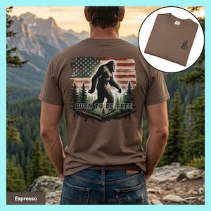 May include: Espresso-colored t-shirt featuring a Bigfoot graphic with an American flag and the text "BORN TO BE FREE." The shirt has a crew neck and short sleeves. A smaller image of the shirt is in the upper right corner.